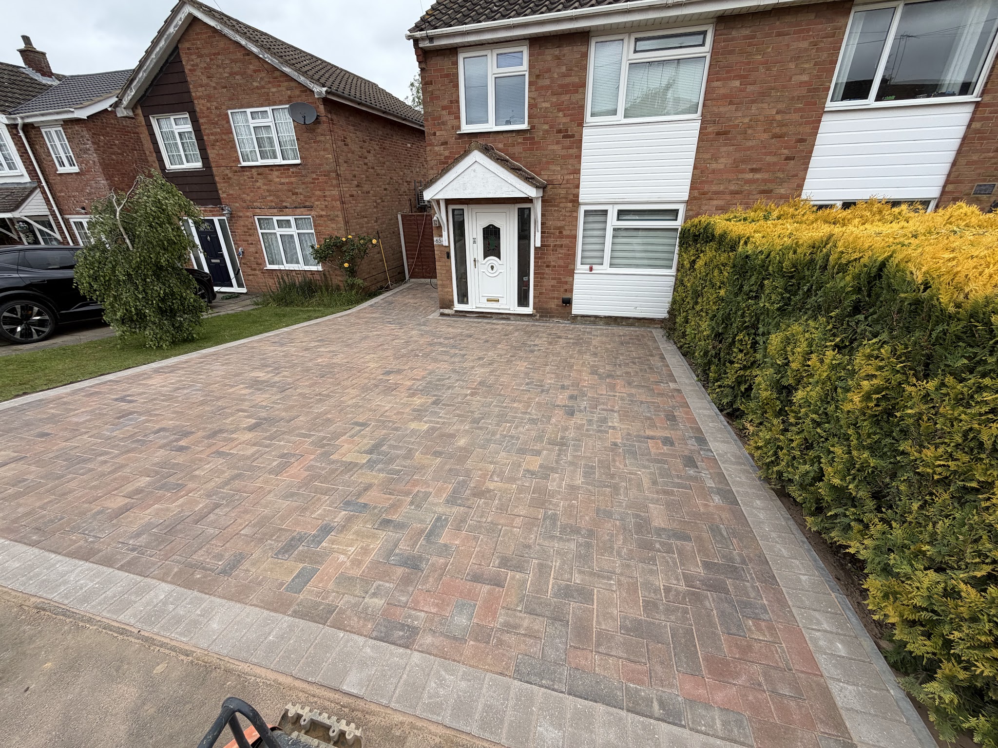 Block-paved driveway with a light border leading up to a semi-detached house